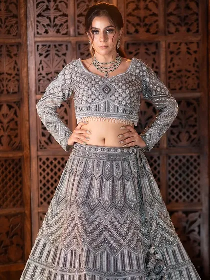 For a modern reception or sangeet look, this stunning silver-grey lehenga is a perfect choice. The intricate beadwork and contemporary design will make sure all eyes are on you.