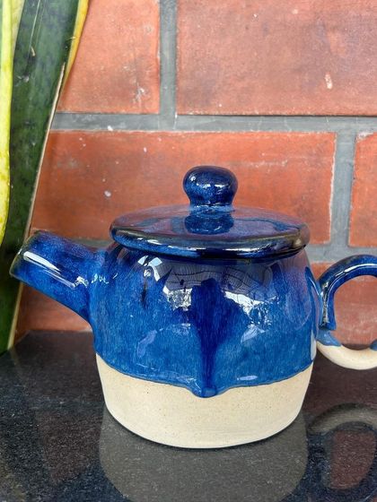 Another beautiful blue teapot created by a student, this one with a classic round handle.