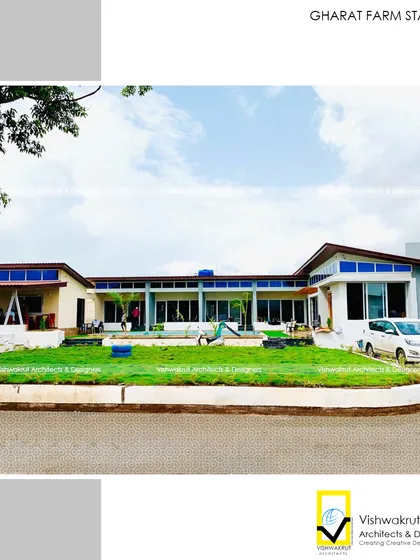 The main building of Gharat Farm Stay, viewed from the lawn. The architecture features clean lines and large windows, designed to maximize natural light and offer beautiful views of the surrounding Pali hills.