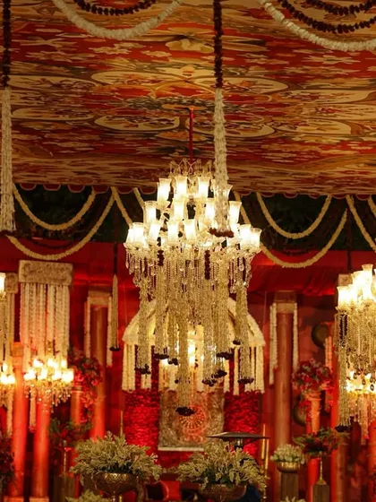 The ceiling was a canvas of its own, with a traditional printed fabric adorned with dozens of floral-draped chandeliers, creating a sky of light and opulence.