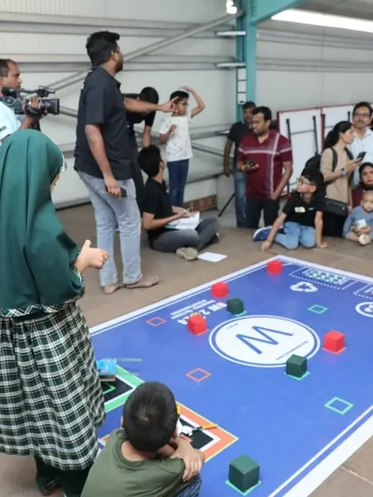 Young students watch their robot navigate a challenge mat during our RW2024 competition. This is the culmination of their hard work, where they see their programming skills come to life.