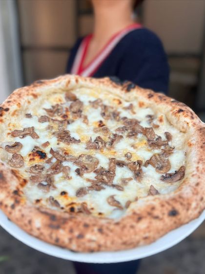 Holding up our Pizza Bianca. It's a simple but elegant pizza that lets the quality of the ingredients shine.