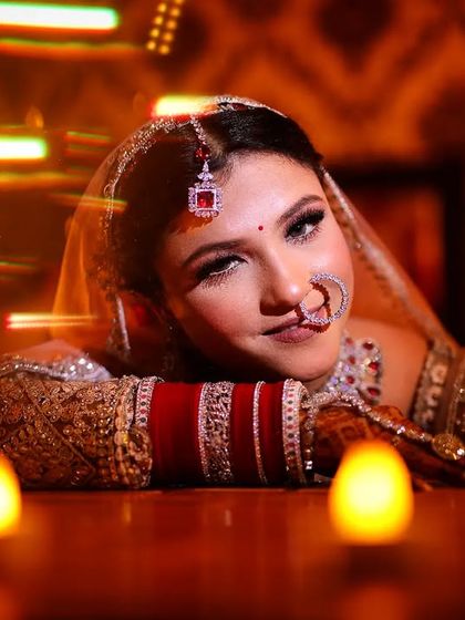 A playful bride winks at the camera, surrounded by the warm glow of candles.