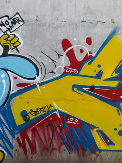 A close-up of the "No War" mural, showing the character holding a peace flag next to a section of graffiti lettering. This is how I combine characters and typography to deliver a message.