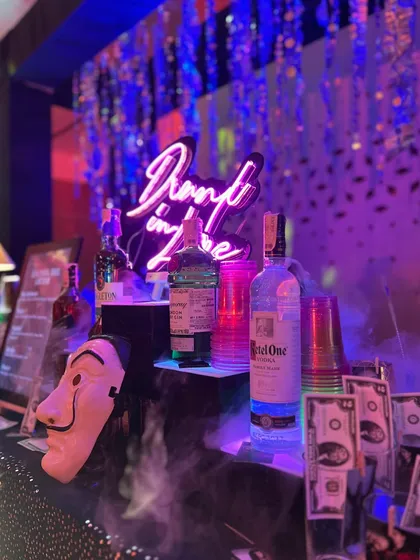 Our Money Heist themed bar in full swing. We bring the theme to life with details like Dali masks, prop money, and a custom "Drunk in Love" neon sign, creating an immersive experience for your sangeet or cocktail night.