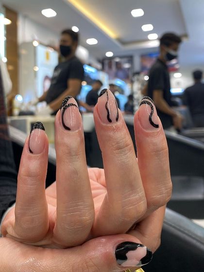 A modern and abstract design with black swirls on a clear or neutral base, perfect for someone who wants artistic and edgy nails.