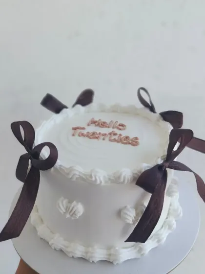 A "Hello Twenties" vintage cake with brown ribbons, a perfect way to celebrate a milestone birthday in style.