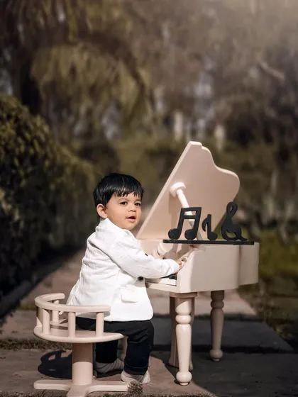 A little maestro in a sharp white jacket. He looks focused and ready to play in this classic and elegant outdoor musical portrait.