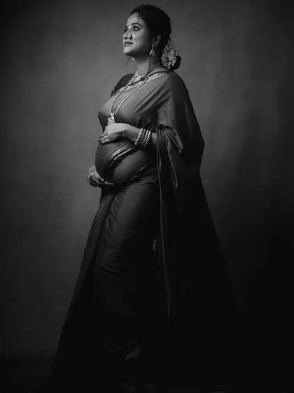 A classic black and white maternity portrait, capturing the expectant mother looking upwards with a hopeful expression.