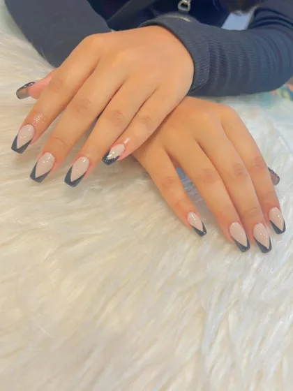 This V-shaped French manicure, also known as a chevron tip, is a sharp and modern alternative to the classic curve. The deep V-cut in black creates a bold, graphic look that elongates the nails.
