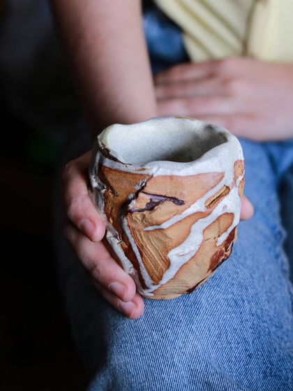 Holding a hand-built Kurinuki cup. As a potter, I am constantly learning and pushing myself to grow, whether it's through making functional ceramics for cafes or teaching long-form courses.