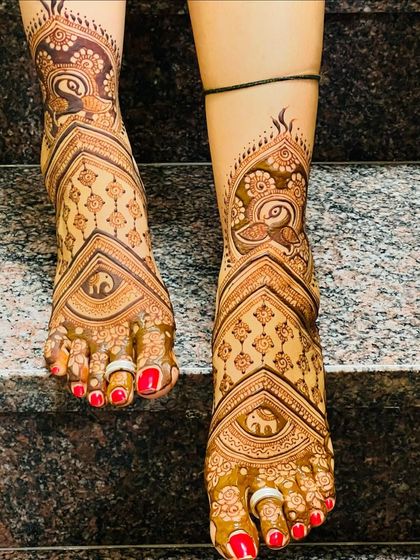 A stunningly detailed foot design with elephants and peacocks, covering the entire foot in beautiful patterns.