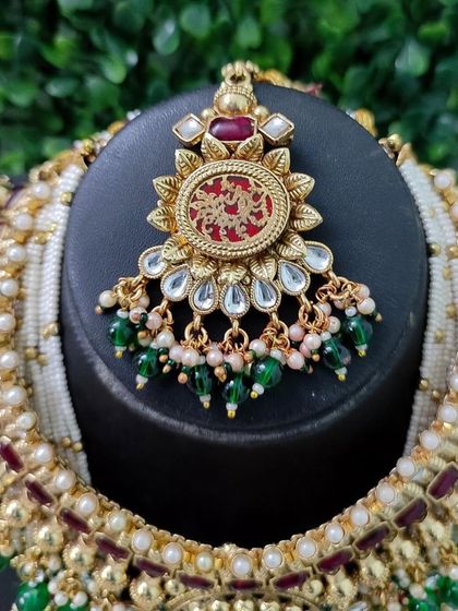 The beautiful maang tikka from this set, featuring the same red engraved pendant design to create a perfectly coordinated bridal look.