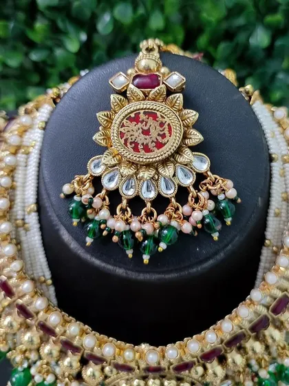 The beautiful maang tikka from this set, featuring the same red engraved pendant design to create a perfectly coordinated bridal look.