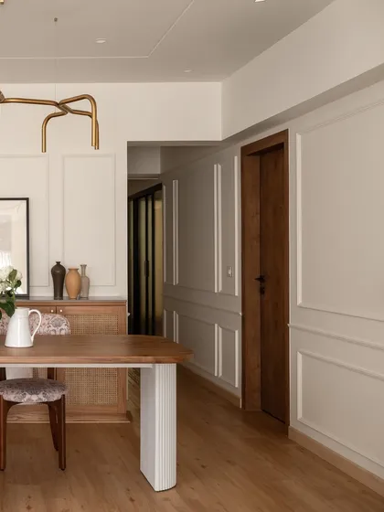 A glimpse into the dining and living area of "Apartment 222." The design emphasizes clean lines and a harmonious blend of textures, from the wooden floors to the paneled walls, creating a cohesive and tranquil environment.
