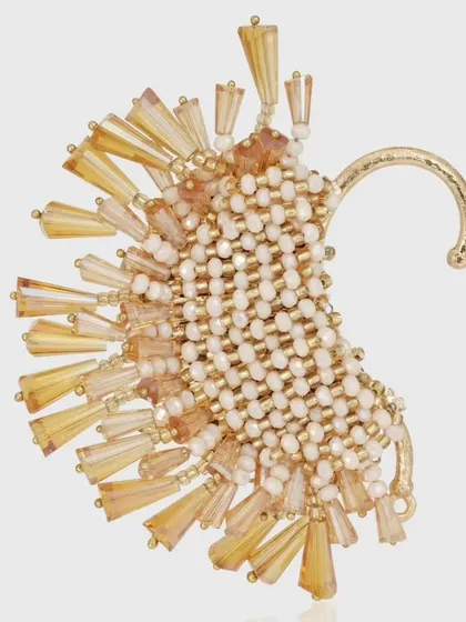 This golden earcuff features a woven bead base with radiating crystal pipes, a true piece of wearable art.