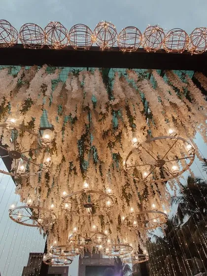 This angle highlights the intricate ceiling work of the entrance. The combination of hanging white florals and a dense network of lights creates a truly immersive and awe-inspiring effect.