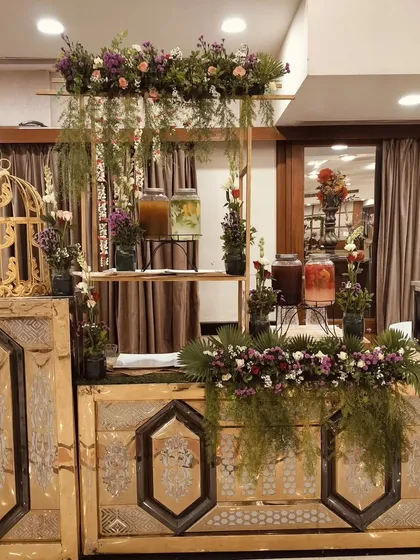 Another view of the rustic-chic beverage station, showing the arrangement of dispensers and floral decor.