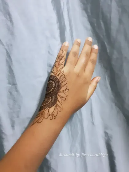 The outline stage of the bold henna design, showing the framework before filling.