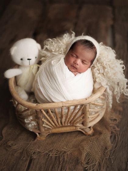 This family traveled all the way from Dahanu for their session, and I'm so grateful. We created this beautiful memory with their 15-day-old baby boy, cozy in a basket with his teddy.