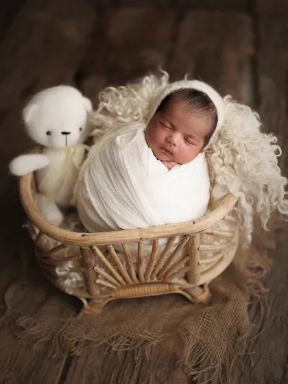 This family traveled all the way from Dahanu for their session, and I'm so grateful. We created this beautiful memory with their 15-day-old baby boy, cozy in a basket with his teddy.