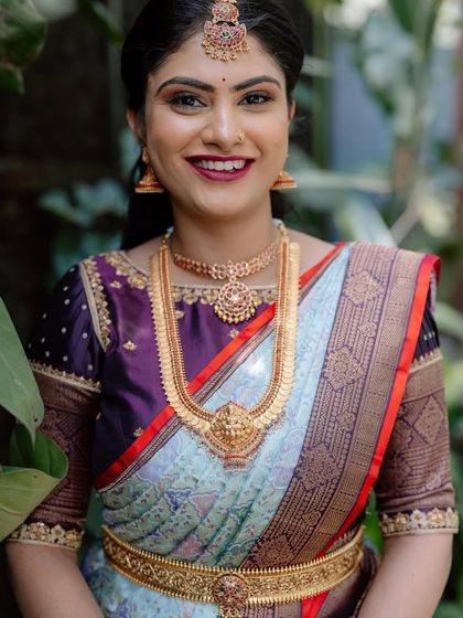 A bride in a beautiful pastel blue and maroon saree. The contrast of the soft blue with the rich maroon creates a unique and striking look.