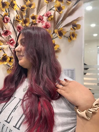 A final look at the client enjoying her new red ombre hair. The style is both edgy and glamorous.
