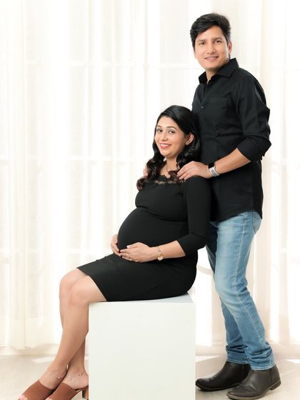 A classic seated portrait of a couple in casual black shirts and jeans. It's a simple, clean look that always works beautifully.