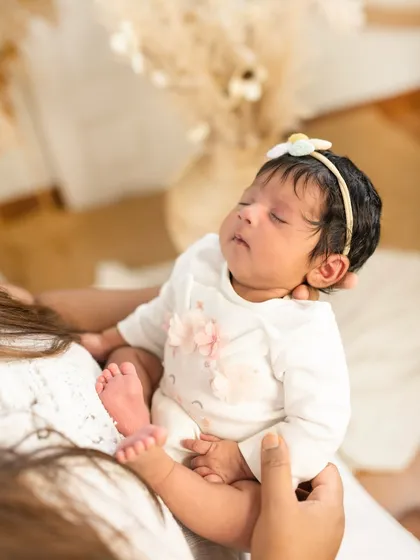The safety of a parent's hands. This shot from a one-month session shows just how tiny they are, a memory you'll want to hold onto forever.