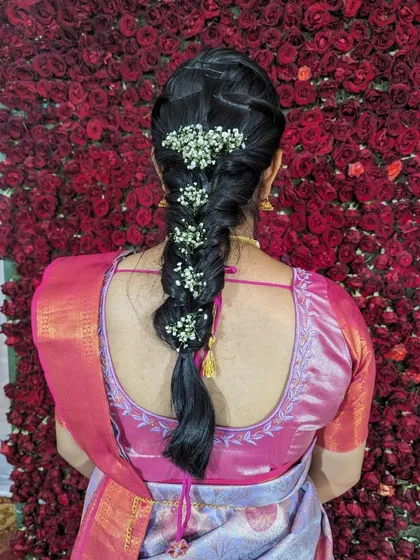Hairstyling is an integral part of the makeover. This traditional South Indian braid, woven with delicate baby's breath flowers, was designed to perfectly complement the client's silk saree and the wedding event.