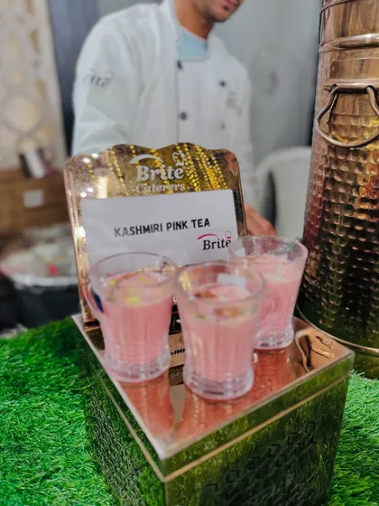 My chef stands behind the Kashmiri Pink Tea display, ready to serve this special beverage.