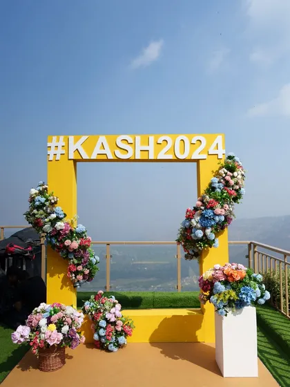 The complete selfie booth setup, with colorful floral arrangements that make the entire corner picture-perfect.