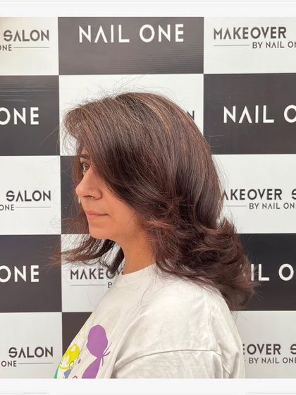 A side view of the client's new hairstyle, showing how the layers frame her face and the subtle color adds dimension.