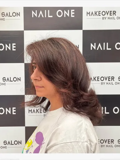 A side view of the client's new hairstyle, showing how the layers frame her face and the subtle color adds dimension.