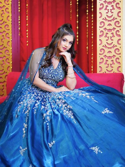 A seated portrait against a rich red backdrop, creating a beautiful color contrast.