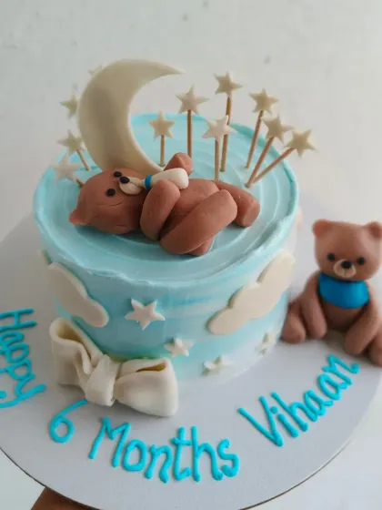 A sweet cake to celebrate a half birthday! This 6-month celebration cake features a sleeping teddy bear on a moon, surrounded by stars.