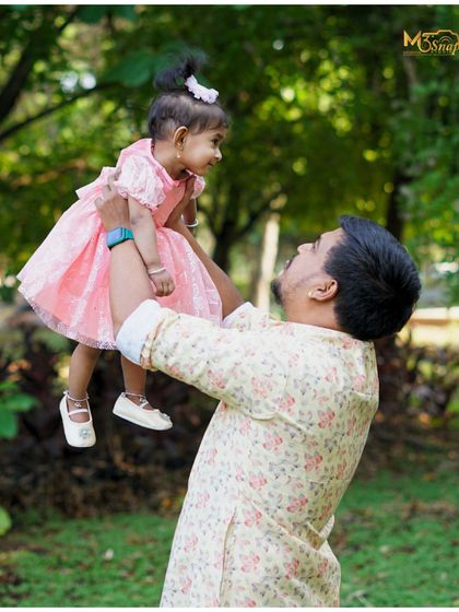 The special bond between a father and his daughter. This candid shot captures a moment of play and affection, showing a connection that is truly heartwarming.