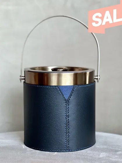 A close-up of our Bella Pelle Casa Ice Bucket, highlighting the fine stitching and the elegant contrast between the navy leather and brushed metal handle. This piece is on sale for a limited time.