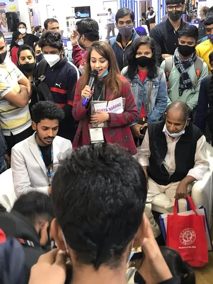 Using a microphone to engage a large crowd that has gathered at the booth. Even in a noisy exhibition hall, my show commands attention and keeps the audience captivated.