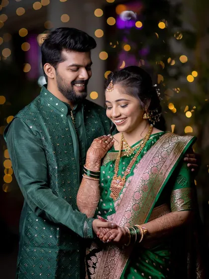 A joyful couple portrait, capturing their smiles and the beautiful details of their green engagement outfits.