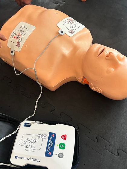 The AED and training dummy, essential tools for our first aid certification.
