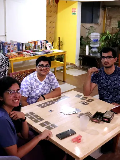 Three friends getting ready for a game of 'Omerta'. The shelf of board games in the background shows just a fraction of what I have to offer.