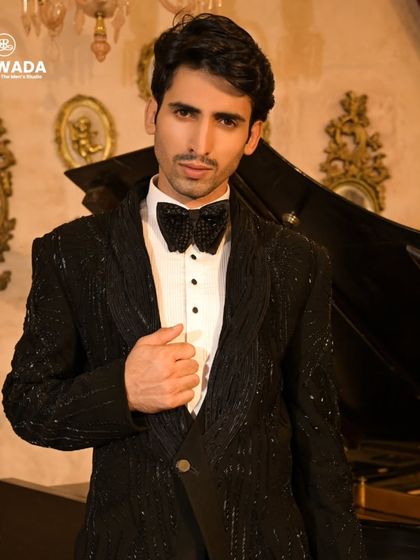 A close-up portrait, focusing on the detailed bow tie and the shimmering lapels of the tuxedo.