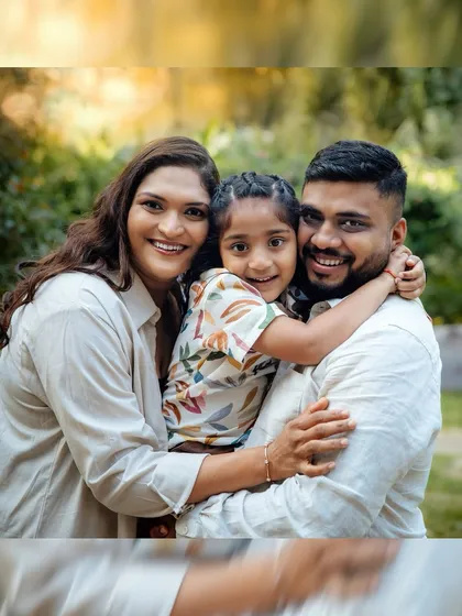 A classic family portrait taken outdoors, surrounded by lush greenery. The natural setting adds a warm and relaxed feel to this beautiful picture of a happy family.