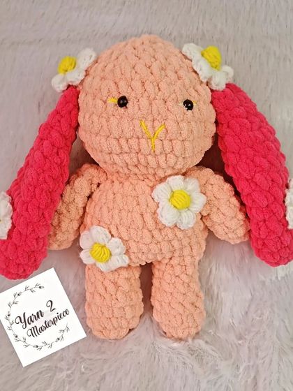 A long-eared plush bunny decorated with daisies, perfect for a spring-themed gift.