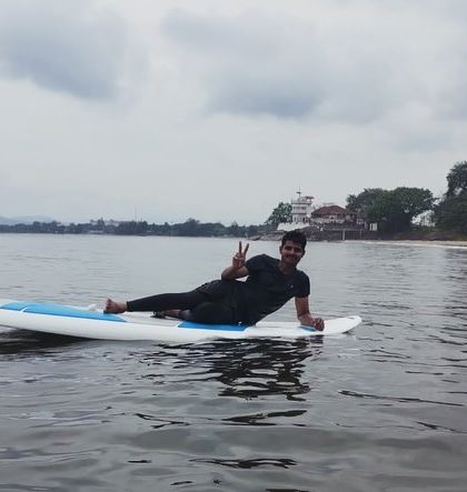 A camper relaxes on a paddleboard at our Karwar summer camp, enjoying a peaceful moment on the water.