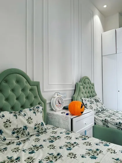 This neo-classical themed kids' room in Gurugram demonstrates how classic design can be adapted for a youthful space. I used elegant wall moulding to add dimension and formality, while the custom-designed twin beds with tufted headboards in a soft green fabric provide a playful yet sophisticated touch.