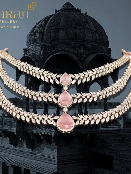 A full product shot of the three-layered pink stone and zircon necklace, showcasing its beautiful design against a dramatic background. This piece is a true work of art.