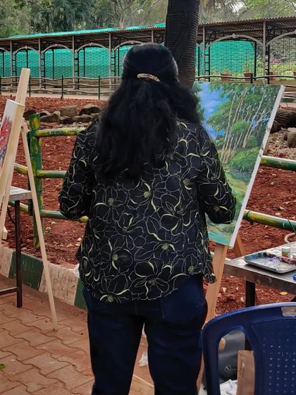 A view from behind, showing me at my easel, painting the beautiful scenery of the park.