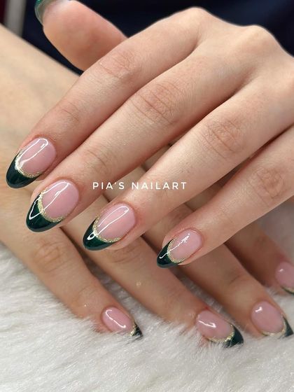 A sophisticated festive look. This design features a deep forest green French tip with a delicate gold chrome outline.